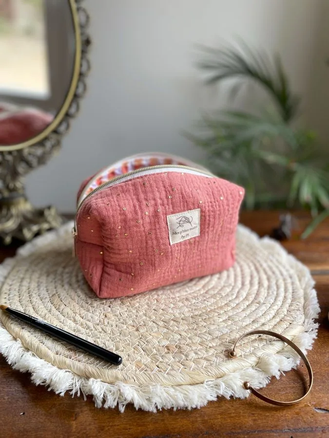 trousse gaze de coton rose marsala pois dorés. Doublure en vichy sorbet assortie. Curseur doré et fermeture par zip descendant sur les côtés.